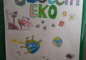 Plakat wykonany przez dzieci: napis "Jestem EKO" oraz rysunki zachęcające do dbania o Ziemię.