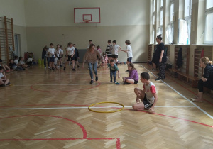 Sala gimnastyczna. Dzieci biorą udział zawodach sportowych - wyścigi rzędów.