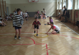 Sala gimnastyczna. Dzieci biorą udział zawodach sportowych - wyścigi rzędów.