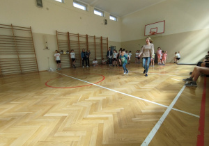 Sala gimnastyczna. Dzieci biorą udział zawodach sportowych - wyścigi rzędów.