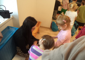 Dziewczynka z grupy Motylków głaszcze kota. Na zdjęciu widoczna jest również Pani z Fundacji "Kocia Mama"