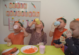 Dzieci piją sok z marchewki.