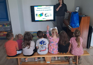 Na zdjęciu widoczna jest Przedstawiciela MPO Łódź oraz dzieci, które uważnie słuchają informacji na temat świadomej segregacji odpadów oraz recyklingu.