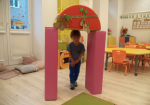 Chłopczyk przechodzi przez bramę udekorowaną ziemniakami.