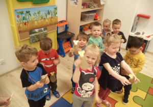 Dzieci pozują do zdjęcia z medalami w kształcie ziemniaka.