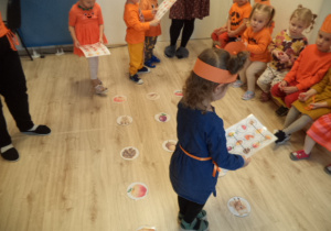 Czwórka dzieci graz w zabawę z kodowaniem. Reszta dzieci je obserwuje.