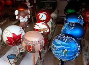 Na zdjęciu widać bombki w różnych kolorach i kształtach suszące się na gwoździkach.