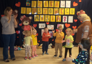 Dzieci tańczą na tle dekoracji z okazji Dnia Pluszowego Misia.