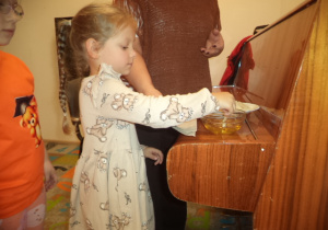 Dziewczynka moczy wafelek w miodzie.