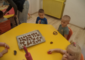 Na zdjęciu widać dzieci wycinające pierniczki.