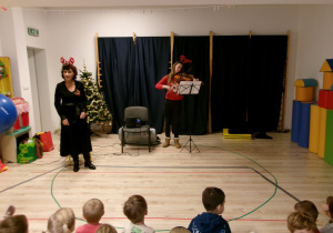 Na zdjęciu widoczne są dwie Panie prowadzące grudniową audycję muzyczną - jedna z Pań gra na altówce, a druga śpiewa i prowadzi świąteczne spotkanie muzyczne.