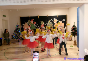 Starszaki tańczą do znanej piosenki, z wykorzystaniem złotych pomponów. Dziewczynki mają czerwone spódniczki i białe bluzki, a chłopcy ciemne spodnie i białe koszule.