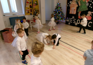Na zdjęciu widać dzieci, które stoją wokół białego okręgu.