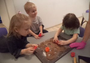 Na zdjęciu widać dzieci, które dekorują pierniczki.