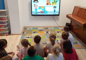 Dzieci ogladają film edukacyjny z okazji Dnia Kredki.