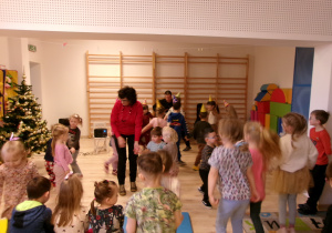 Na zdjęciu widać dzieci tańczące do muzyki granej Przez pana na gitarze elkytrycznej.