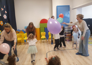 Na zdjęciu widać dzieci, babcie i rodziców bawiących się balonami.