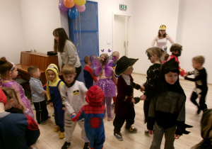 Dzieci przebrane w stroje tańczą na sali gimnastycznej.
