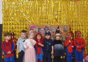 Dzieci z grupy Pszczółek pozują do zdjęcia w przebraniach.
