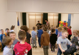 Dzieci wspólnie tańczą do granej muzyki.