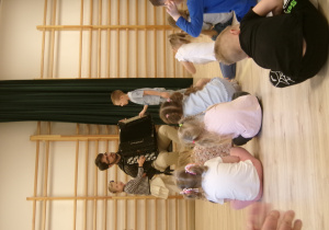 Na zdjęciu widać dzieci, Panią prowadząca audycję muzyczną oraz Pana, który gra na instrumencie (akordeon) oraz dziewczynkę i chłopca, którzy wspólnie próbują grać na akordeonie.