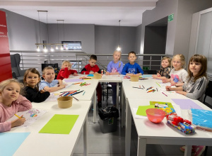 Na zdjęciu widać dzieci znajdujące się w bibliotece, wykonujące prace plastyczne.