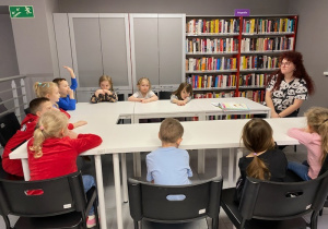 Na zdjęciu widać dzieci znajdujące się w bibliotece, biorące udział w zajęciach.