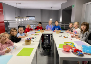 Na zdjęciu widać dzieci znajdujące się w bibliotece, wykonujące prace plastyczne.