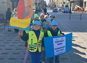 Na zdjęciu widać dzieci znajdujące się na ulicy Piotrkowskiej, trzymające baner przedszkola oraz baner Światowego Dnia Autyzmu.