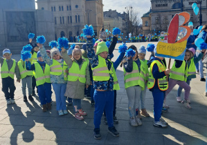 Na zdjęciu widać dzieci znajdujące się na Placu Wolności, trzymające niebieskie pompony.