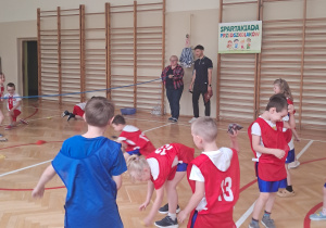 Na zdjęciu widać dzieci przerzucające przez linę kolorowe woreczki.