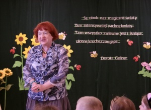 Na zdjęciu widać Panią Dorotę Gellner na tle dekoracji z cytatem z jej książki.