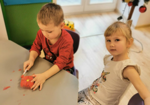 Chłopiec siedzi przy stoliku. Czerwoną farbą maluje odcięty spód plastikowej butelki. Obok siedzi dziewczynka.