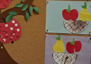 Tablica z pracami dzieci. Koszyczki pomalowane kredkami, w których znajdują się jabłka i gruszki złożone z dwóch części.