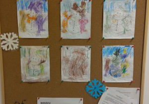 Tablica z pracami dzieci. Kolorowanki przedstawiające dzieci lepiące bałwana.