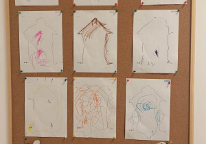 Tablica z pracami dzieci. 9 rysunków przedstawiających dom.