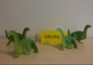 Na szafce stoją papierowe dinozaury (wypychanki) złożone przez dzieci.