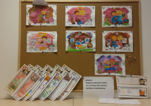 Tablica z pracami dzieci. Na tablicy znajdują się pomalowane farbami kolorowanki oraz wydrukowane zakładki do książek, które zostały pokolorowane przez dzieci.